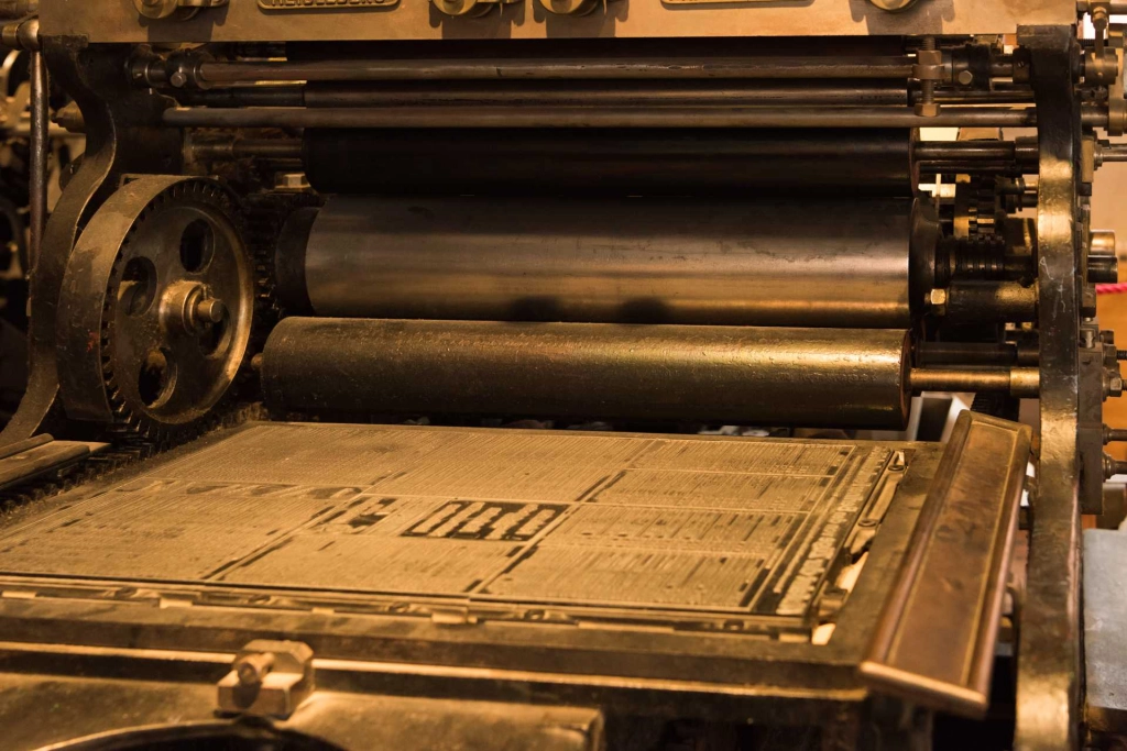 old printing press in sepia, with rollers, plates and cogs