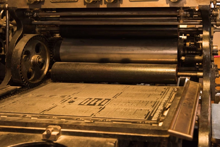 old printing press in sepia, with rollers, plates and cogs