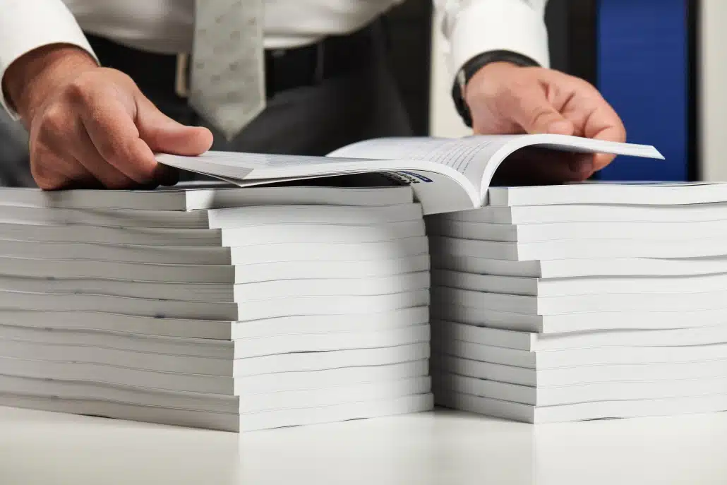 Businessman working at an office, reads stack of books and reports. Business financial accounting concept.