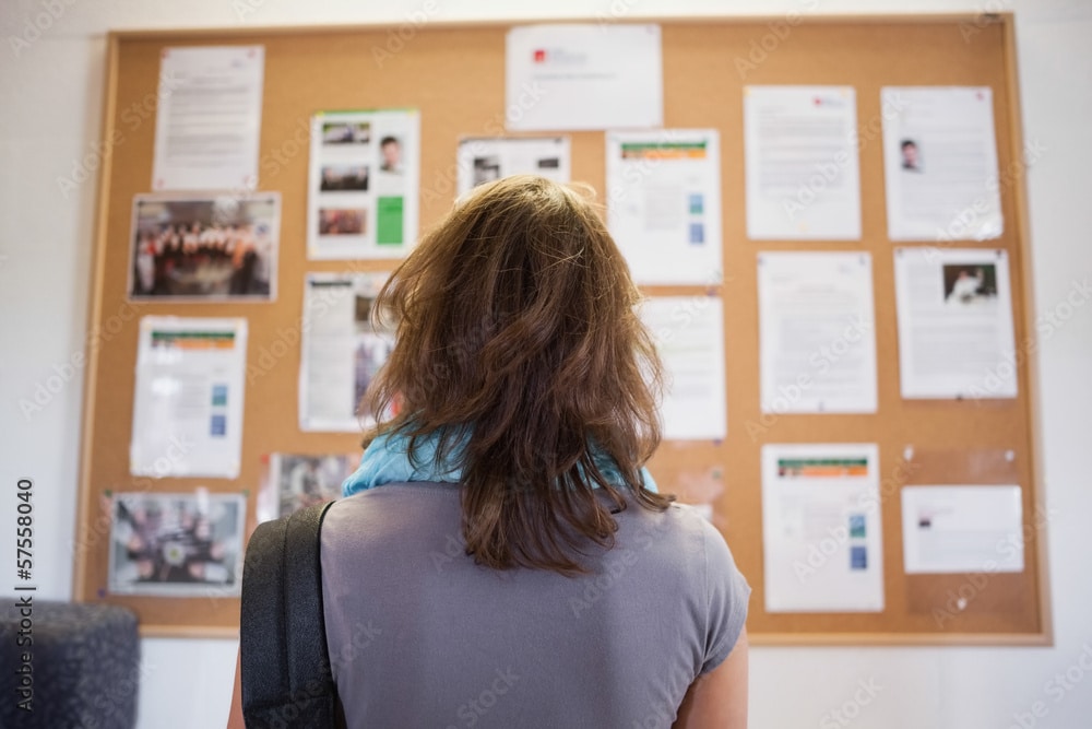 bulletin board with a woman viewing it