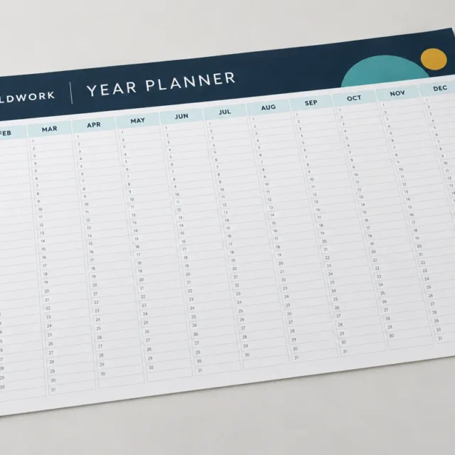 Flat wall planner with a twelve-month grid and a navy and teal illustrative design