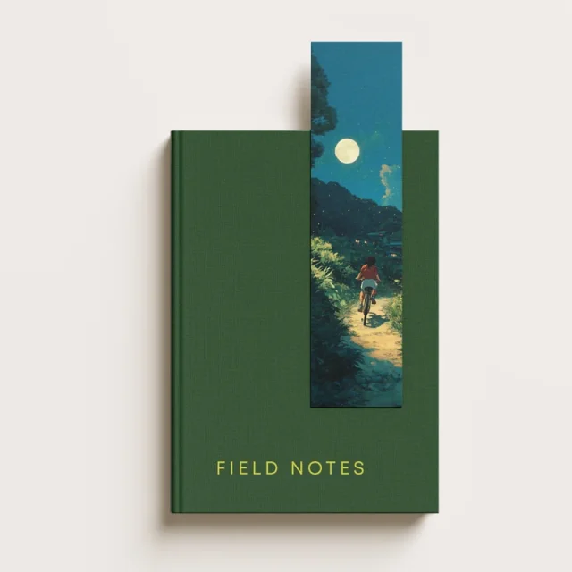 Illustrated bookmark tucked into a green hardback book; book not included